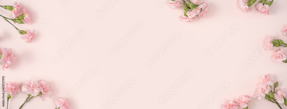 Fototapeta premium Design concept of Mother's day holiday greeting with carnation bouquet on pink table background
