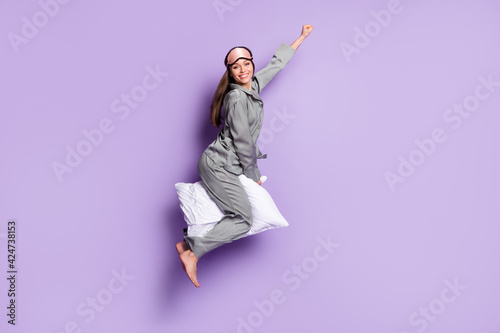 Full length body size photo of pretty woman riding on pillow wearing sleeping mask grey pajama isolated pastel violet color background
