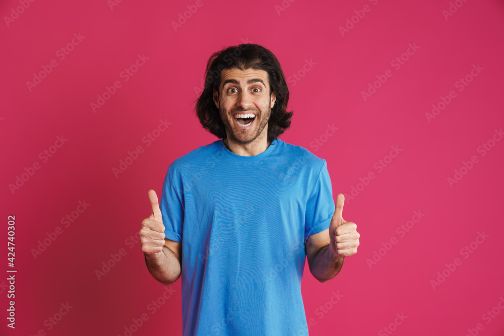 Excited brunette man exclaiming and gesturing thumbs up Excited brunette man exclaiming and gesturing thumbs up