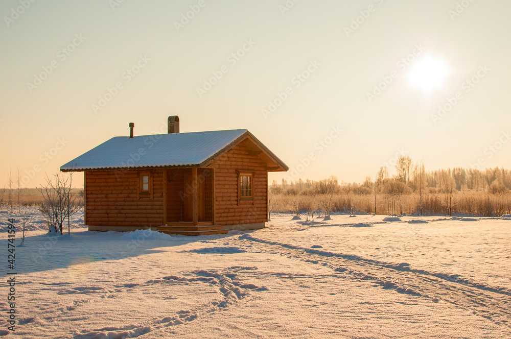 wooden saun house in snow and frozen landscape