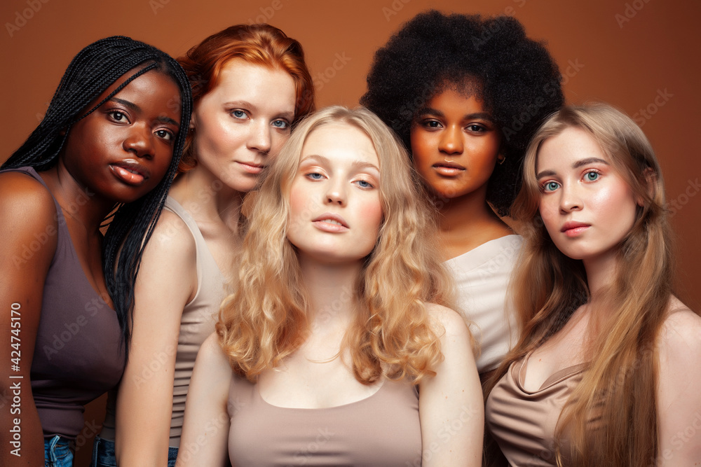 young pretty caucasian, afro, scandinavian woman posing cheerful together on brown background, lifestyle diverse nationality people concept young pretty caucasian, afro, scandinavian woman posing cheerful together on brown background, lifestyle diverse nationality people concept