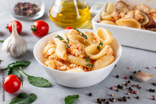 Baked feta pasta in a plate. Fetapasta on a light background. New, popular dinner dish. photo