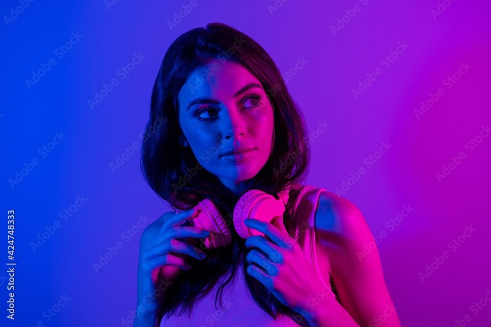 Photo of happy positive beautiful young woman with headphones look copyspace dreaming isolated on glowing background Photo of happy positive beautiful young woman with headphones look copyspace dreaming isolated on glowing background