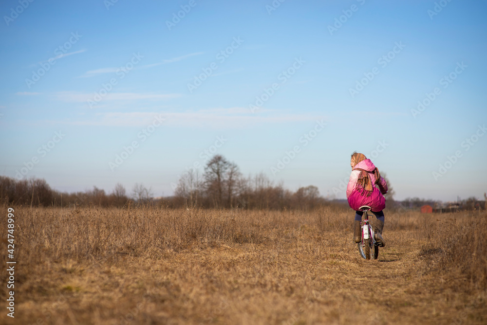 happy girl in national costume-riding a bicycle in early spring, selective focus