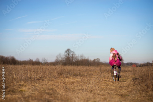 happy girl in national costume-riding a bicycle in early spring, selective focus