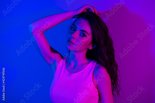 Photo of young stunning beautiful gorgeous girl with long hair posing on camera sensual shot isolated on neon blue color background