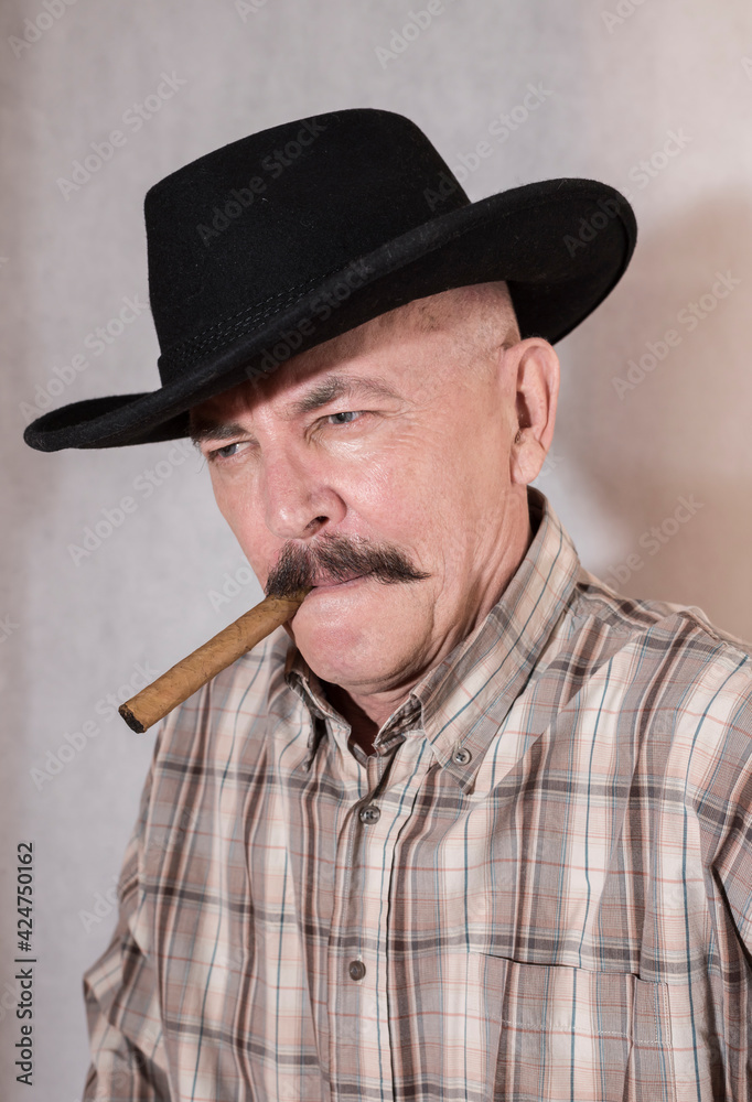 The cowboy with mustache, in a black hat smoking a cigar