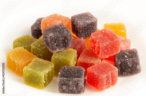 Blurred image of multi-colored gummy candies on a light background.
