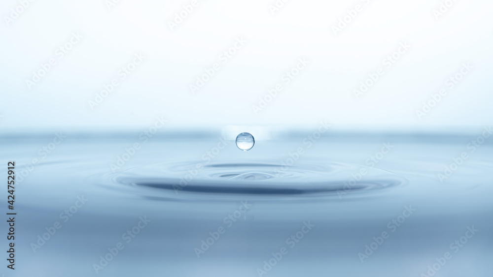 water drop splash in a glass blue colored water drop splash in a glass blue colored