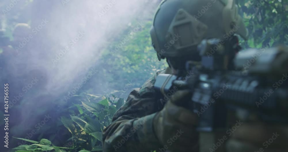 Silhouette of the Fully Equipped Soldier Moving Through Smokey Forest. Military action
