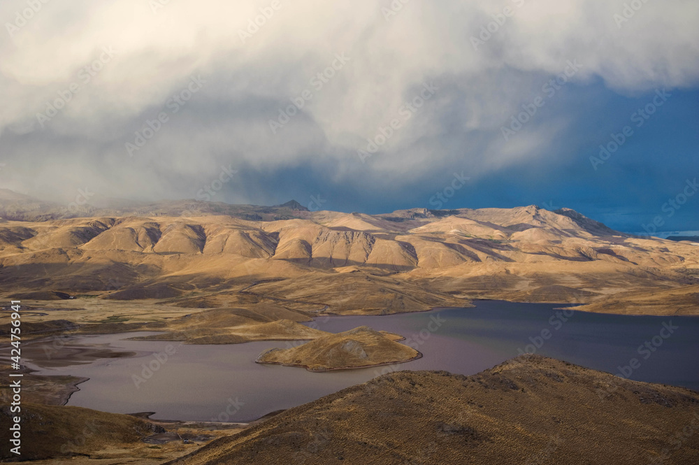 A dramatic landscape overlooking the altiplano in Peru at sunset. Mountains, hills, lakes, lunar landscape.