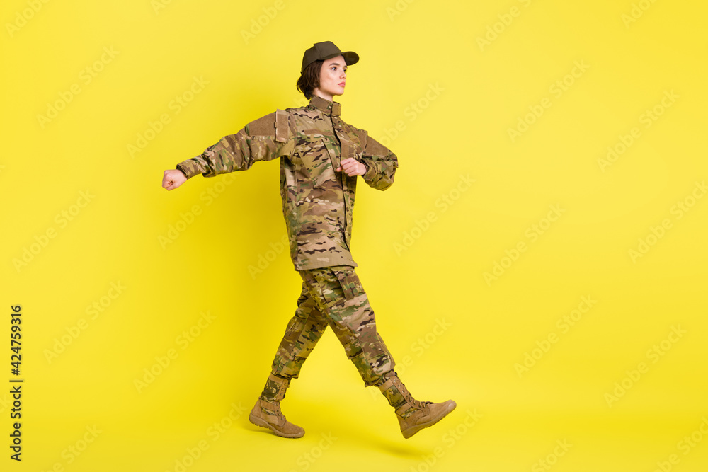 Full size profile photo of calm focused girl look empty space marching isolated on yellow color background Full size profile photo of calm focused girl look empty space marching isolated on yellow color background