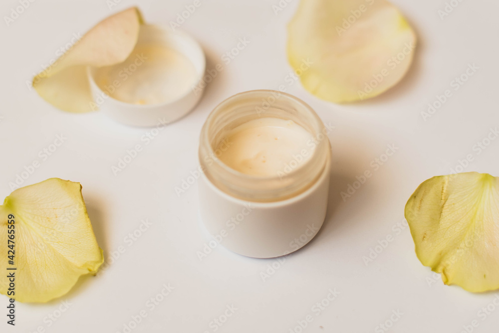 Bowl of cream wiht roses on white background, top view. image of homemade cosmetics ingredients. aroma theme. organic cosmetics. Bowl of cream wiht roses on white background, top view. image of homemade cosmetics ingredients. aroma theme. organic cosmetics.