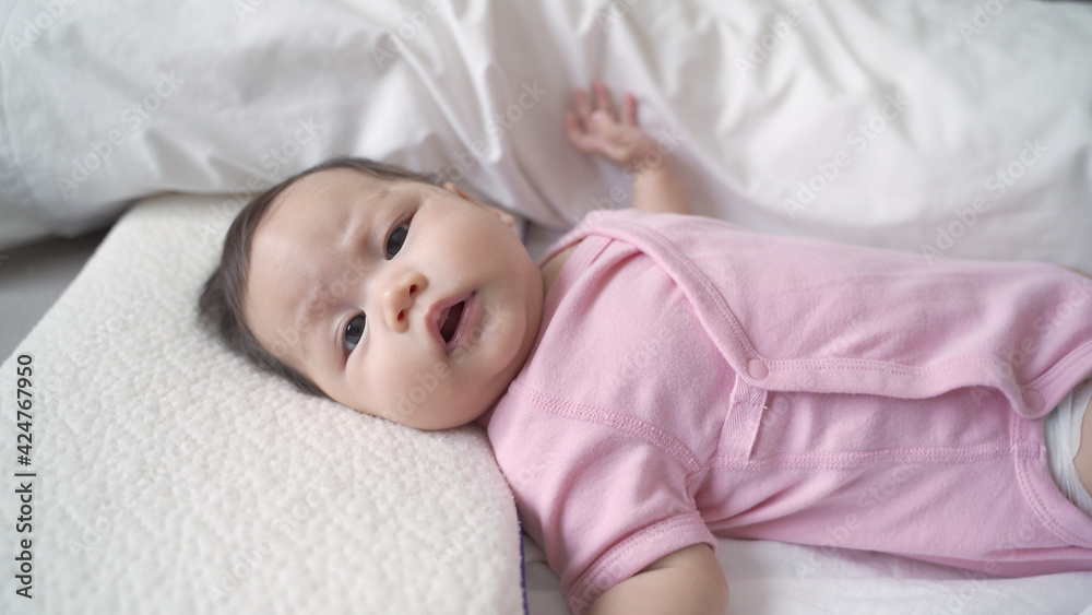 asian baby infant laying down on white soft bed feeling hungry. 3 months old baby facial expression. sign and symptom of hungry in kid. asian baby infant laying down on white soft bed feeling hungry. 3 months old baby facial expression. sign and symptom of hungry in kid.