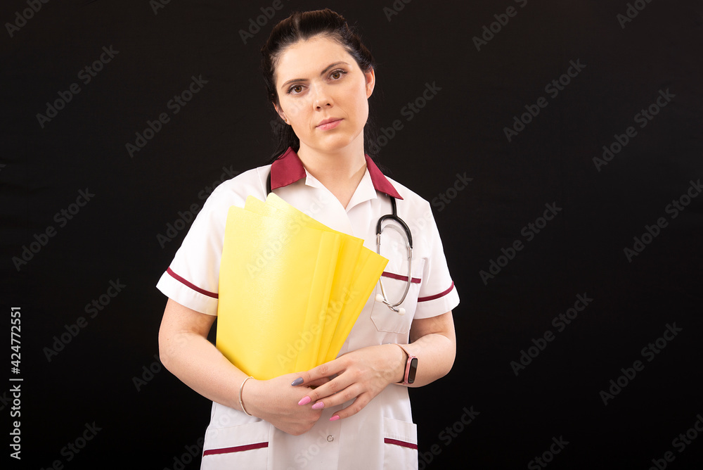 woman doctor with stethoscope and folder of documents on a dark background woman doctor with stethoscope and folder of documents on a dark background