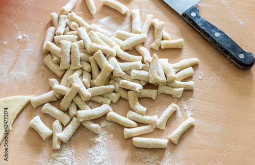 Raw dough or noodle pieces on wooden table