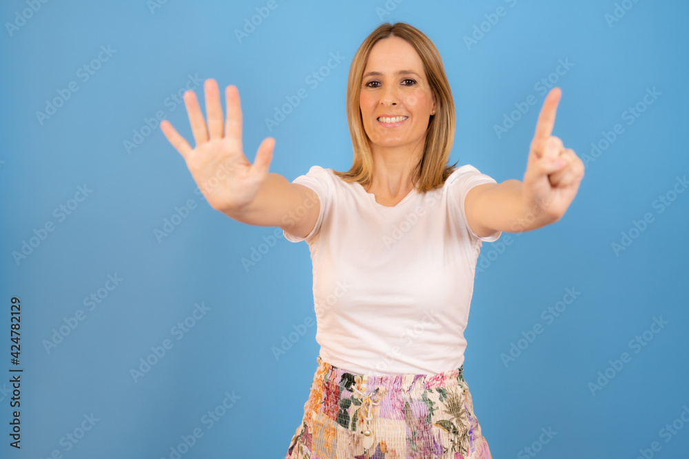 Young caucasian smiling woman counting six isolated over blue background. Young caucasian smiling woman counting six isolated over blue background.