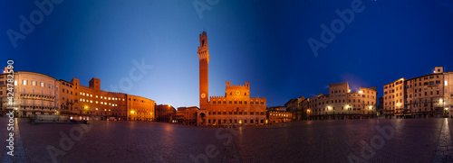 Panorama of the Tuscan city of Siena, Italy, before dawn, showing the Piazza del Campo, the Palazzo Pubblico, and the Torre del Mangia, a slender 14th-century tower.