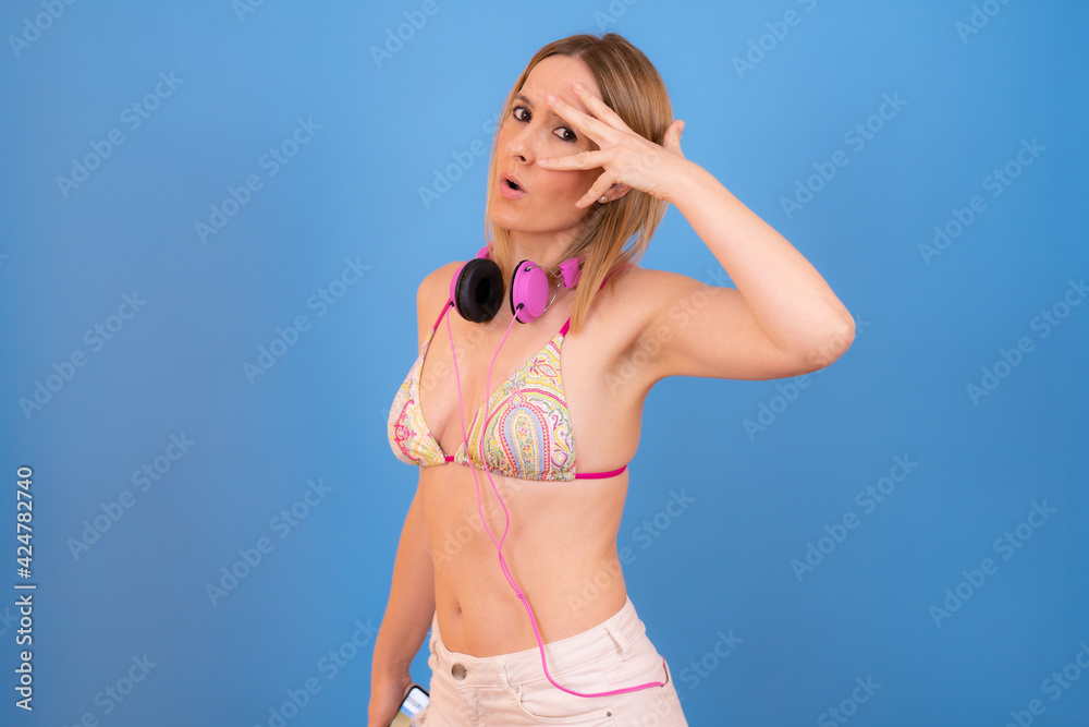 Fototapeta premium Young woman wearing bikini over isolated background smiling and showing victory sign