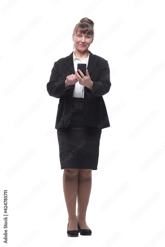Full-length portrait of smiley businesswoman in formal wear looking at smartphone Full-length portrait of smiley businesswoman in formal wear looking at smartphone