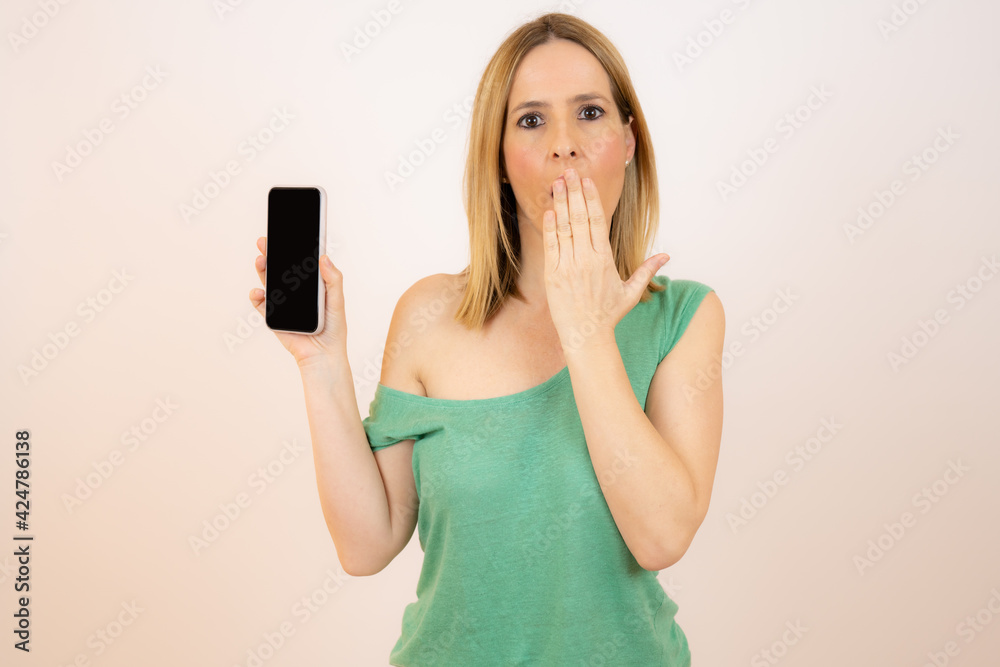 Beautiful young excited woman showing mobile phone isolated over white background. Beautiful young excited woman showing mobile phone isolated over white background.