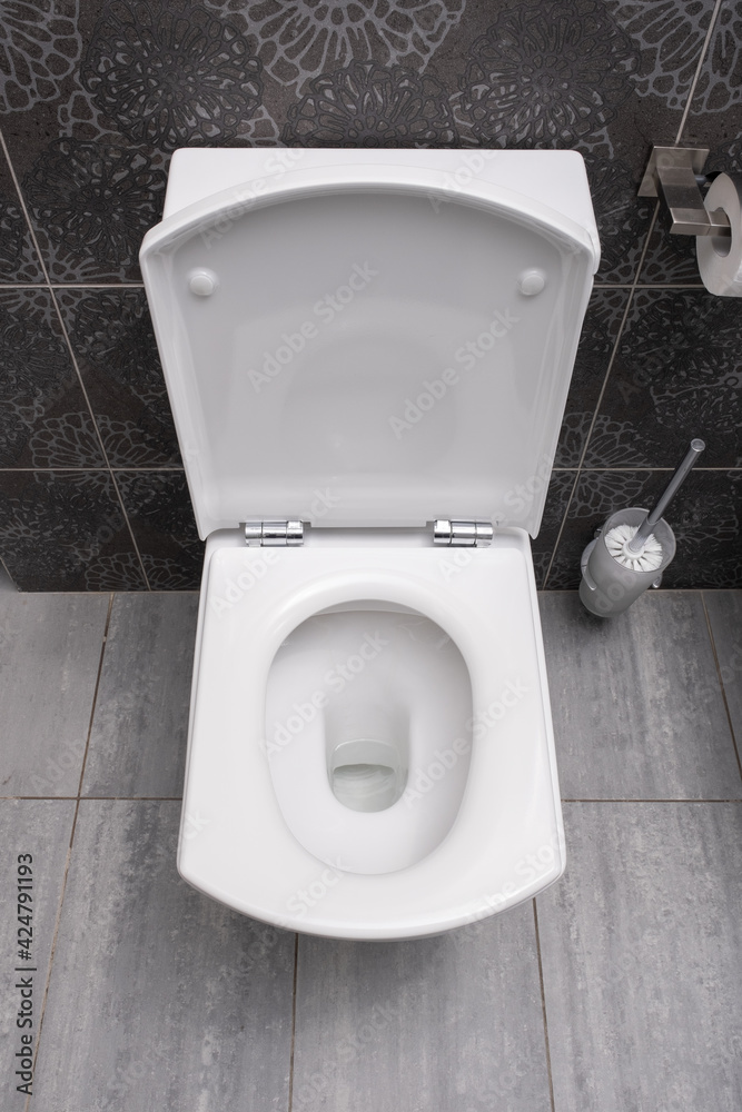 Fototapeta premium White toilet bowl and paper in a bathroom