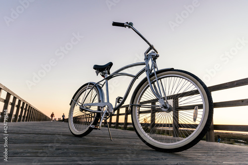 New vintage bike parked in the middle of the wooden boardwalk at sunset