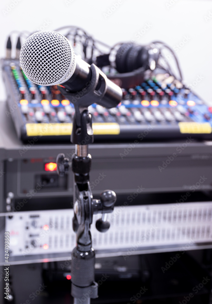 The microphone on tripod with mixer background in sound control room. The microphone on tripod with mixer background in sound control room.