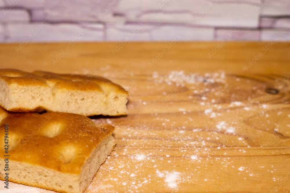 Italian Focaccia bread on a table with flour Italian Focaccia bread on a table with flour