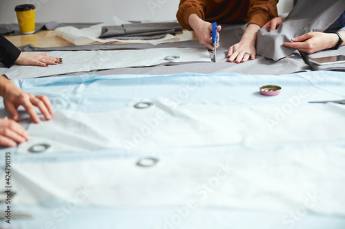 Adult using dressmaking shears on fabric piece