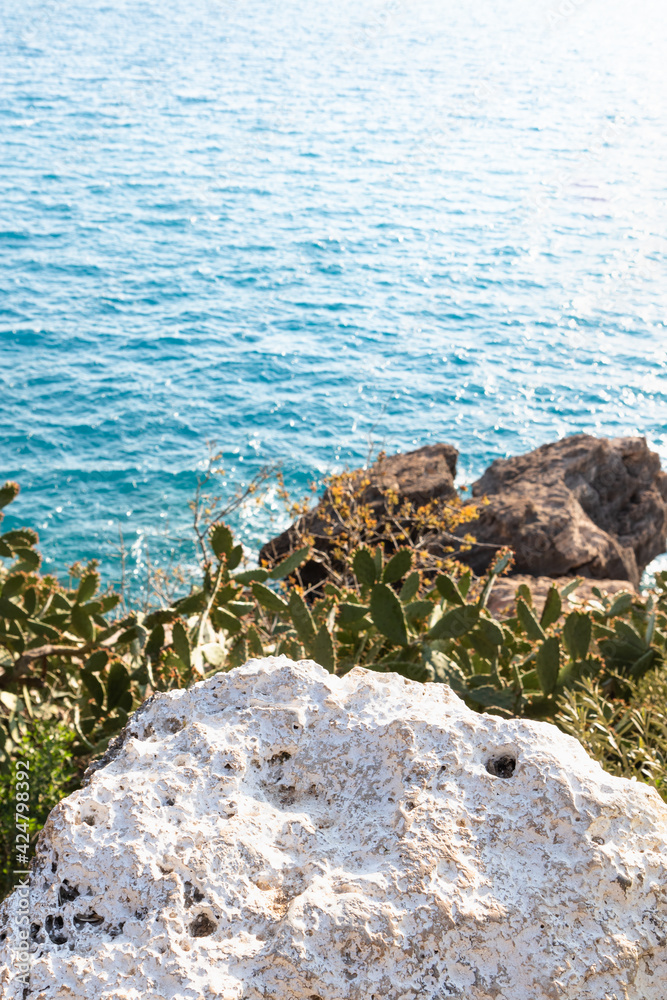 Mediterranean Sea concept. White stone rock above Azur seawater. Selective focus on the stone. Mediterranean Sea concept. White stone rock above Azur seawater. Selective focus on the stone.