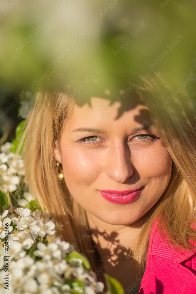 beautiful woman in a pink coat in blooming gardens beautiful woman in a pink coat in blooming gardens