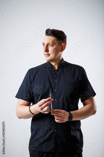 Doctor specialist holds a metal surgical scalpel in his hands