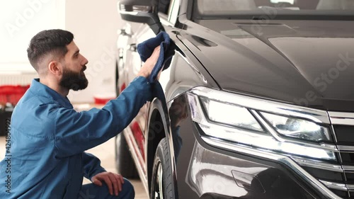 Black car body polishing with polisher tool in auto service