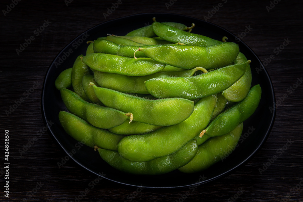 Edamame boiled green soy beans with sea salt on table, traditional Japanese food Edamame boiled green soy beans with sea salt on table, traditional Japanese food