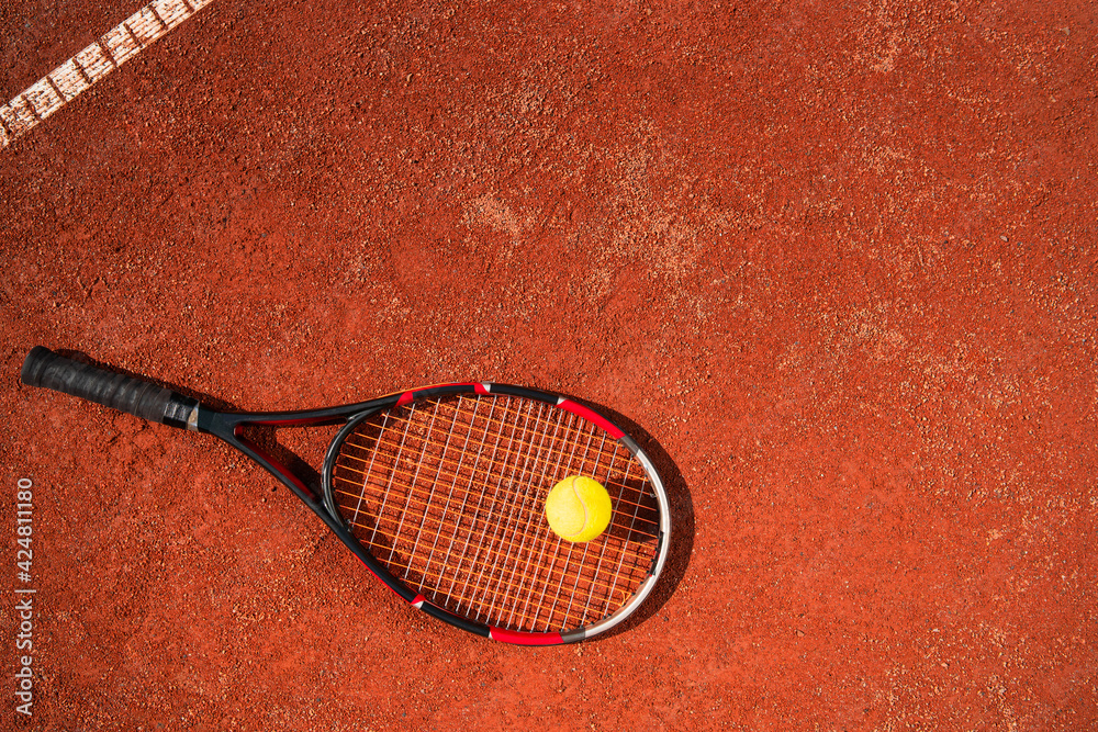 Top view of tennis racket with ball who lying on the surface of the court. Sport concept