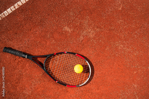 Top view of tennis racket with ball who lying on the surface of the court. Sport concept © Andrii 