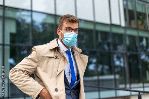 Businessman leaves the office with a face mask protect from Coronavirus. 