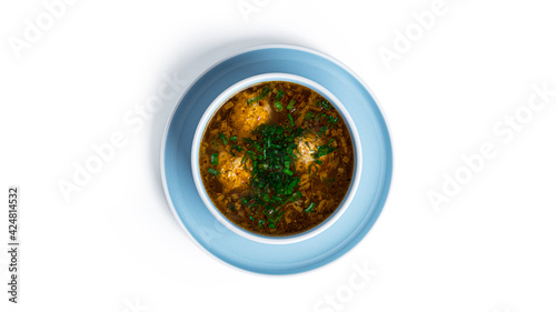 Soup with meatballs in white deep dish isolated on a white background.