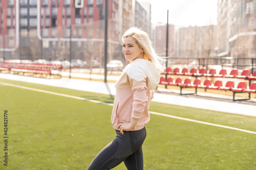 Fitness and sports. Young woman doing stretching at the stadium Fitness and sports. Young woman doing stretching at the stadium
