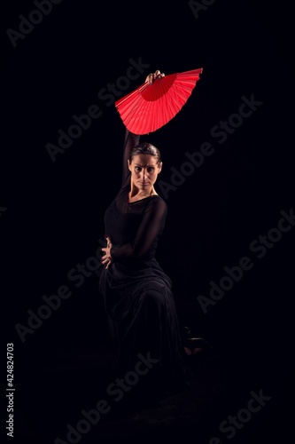 flamenco woman with black dress and red fan above her head