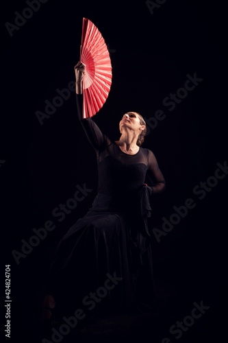 flamenco woman with black dress and red fan looking up