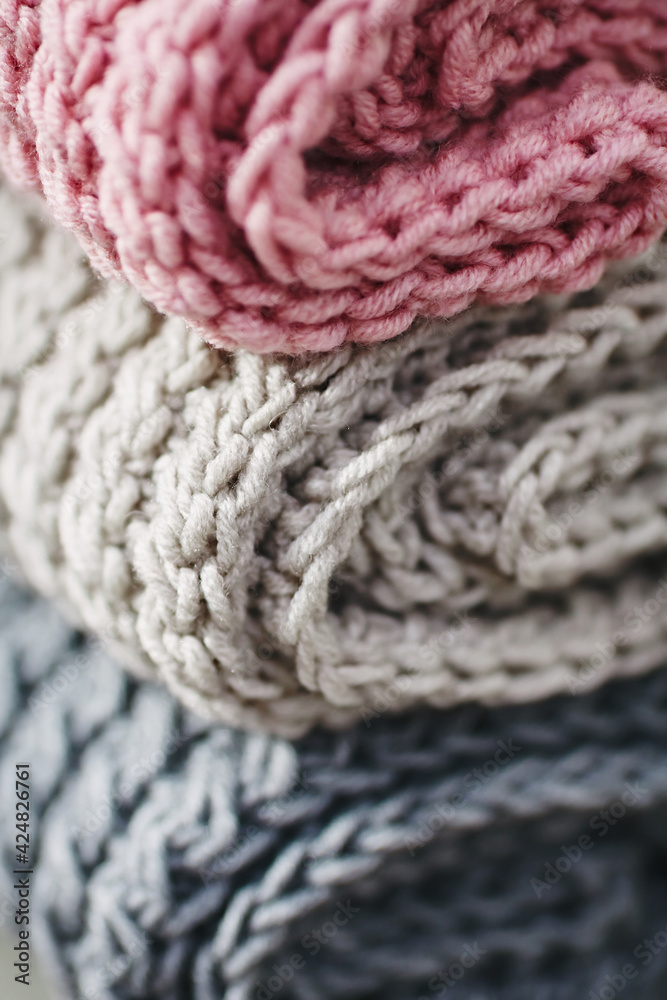 Stack of colorful knitted scarfs and cup. Autumn mood.  Hot cup of coffee. Warm clothes. Selective focus 