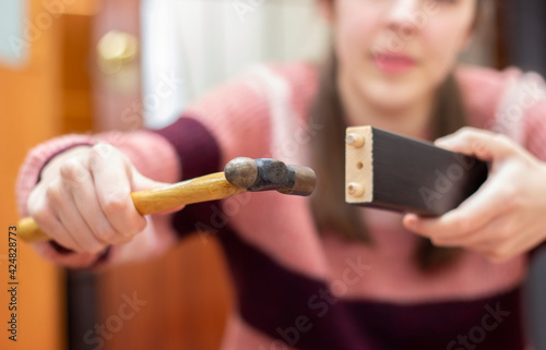 woman hits a wooden block with her hammer