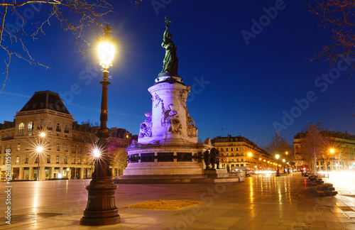 Monument to the republic at night . It is bronze statue of Marianne, a personification of the French republic at the Place de Republique in Paris.