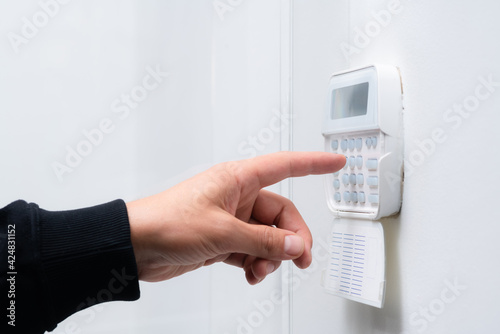 Tela Hand entering alarm system password of an apartment, home or business office