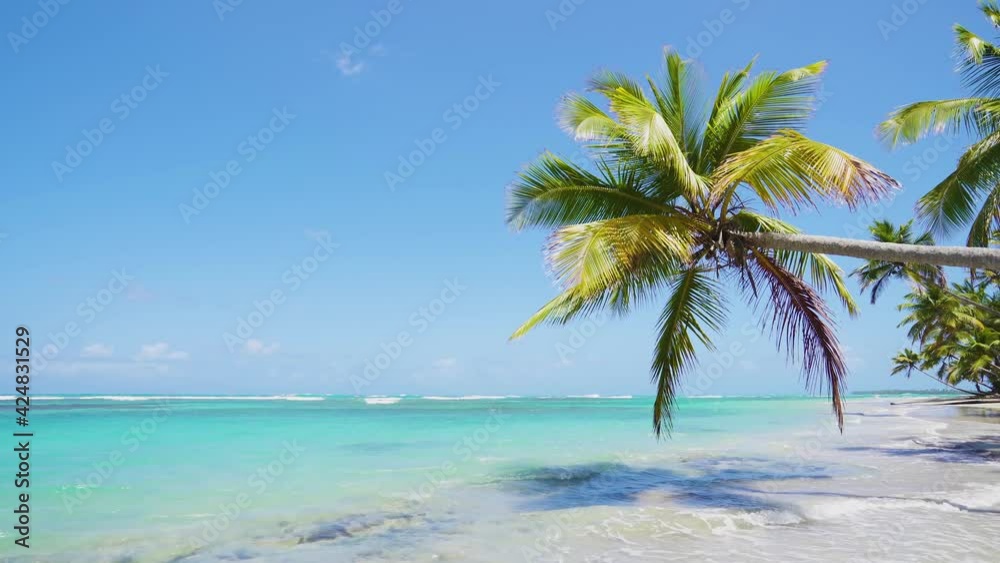 Tropical seaside and beach with azure water and big white waves.