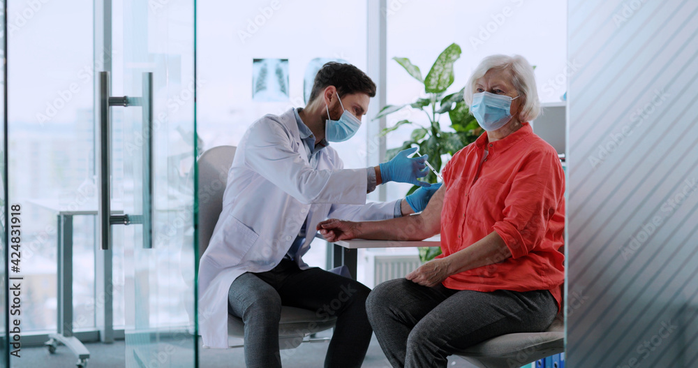 Vaccination concept. Eoderly blonde woman visiting doctor therapist taking injection vaccine against coronavirus influenza. Patient. Vaccination concept. Eoderly blonde woman visiting doctor therapist taking injection vaccine against coronavirus influenza. Patient.