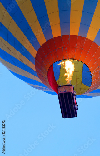 Obraz na płótnie Fragment of a balloon with a basket and a flame of fire from a burner heating the air. w salonie