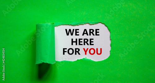 Support symbol. Words 'we are here for you' appearing behind torn green paper. Beautiful green background. Business and support concept. Copy space.